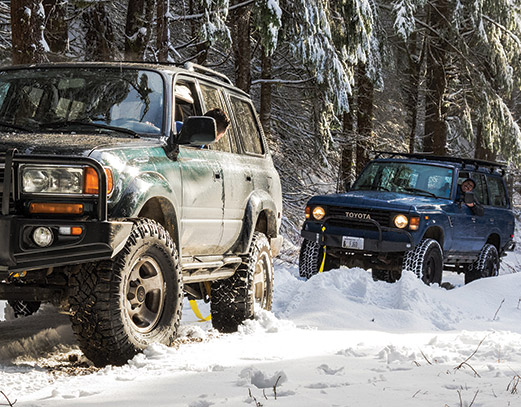 Two vehicles adventuring through the snow.