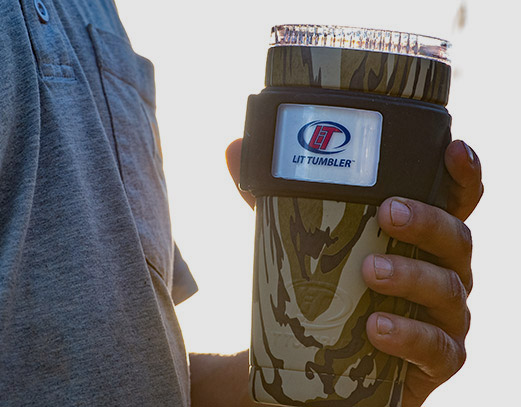 Person holding a camo printed tumbler in their hand.